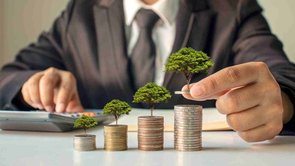 A man in suit putting a tree on stacked of coins